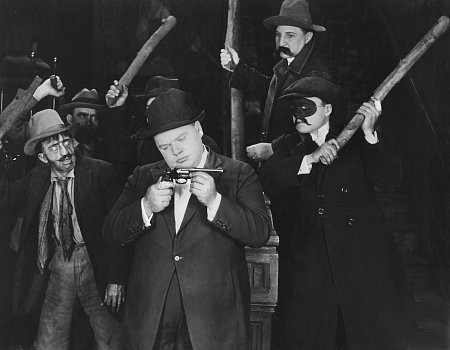 Franklin Pinney (Roscoe 'Fatty' Arbuckle) surrounded by kidnappers.