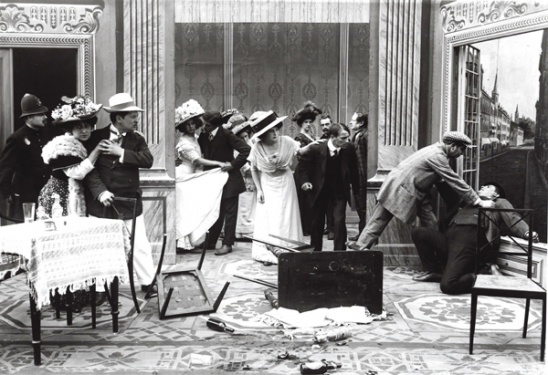 Sherlock Holmes (Otto Lagoni) at the window, Axel Boesen on the left with white hat