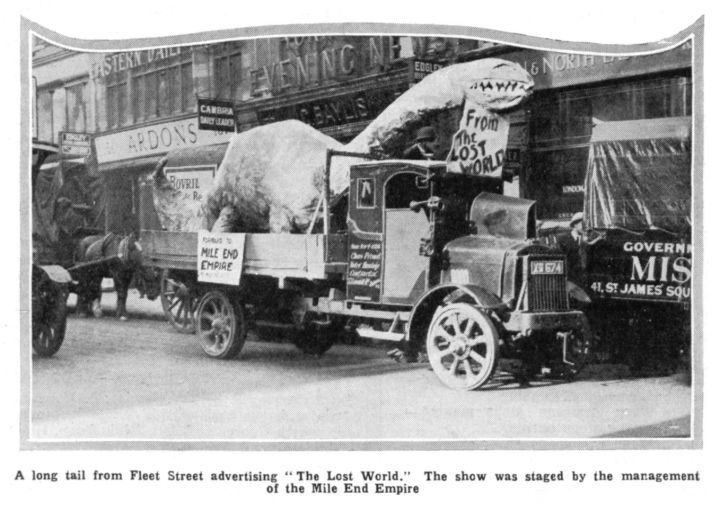 A promotional truck for the movie parades through Fleet Street with a giant dinosaur model mounted on its trailer, drawing attention to the spectacle and advertising the film's run at the Mile End Empire.