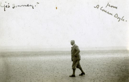 Arthur Conan Doyle walking on a beach (1920s).