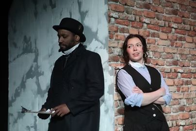 Geoffrey Lestrade (Dominic Gladden) and Miss Sherlock Holmes (Sharon Maguire)