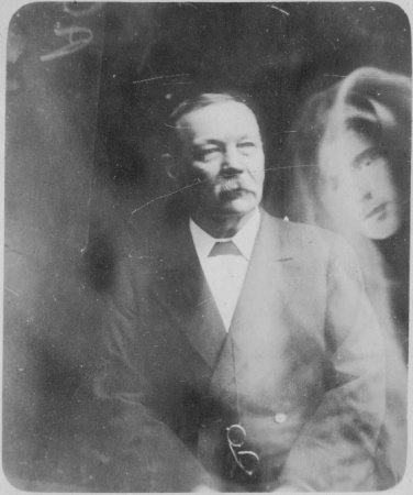 The "spirit" of Kingsley with Arthur Conan Doyle. On the back of the photo Conan Doyle wrote: « This is the head of my son, looking about 7 years younger than he was at death. Every precaution was taken and so far as I could observe no hand but my own ever touched the plate. The photo shows the strange screen marking under a lens which are seen in a certain proportion of Hope's photos. They are not process printing markings for no paper pictures have appeared of such faces. » (1919).